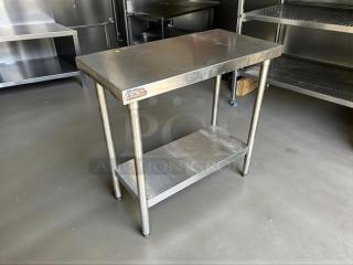 Stainless steel worktop table in great condition, features sturdy legs and lower shelf. Visible label indicates quality.
