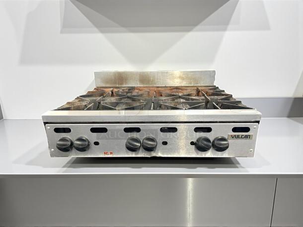 Vulcan VHP636 countertop range, 6 burners, natural gas, 180,000 BTU, in great condition, tested and working, visible logo.