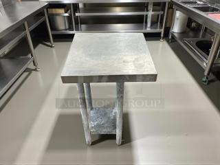 Stainless steel worktop table with a square top and sturdy legs, suitable for kitchen use, in good condition.