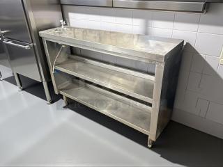 All stainless steel custom-made table with two shelves, sturdy construction, excellent condition, ideal for kitchen use.