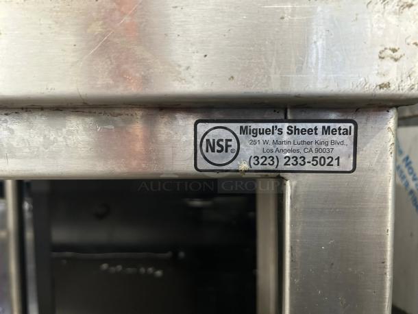 All stainless steel custom-made table with NSF label by Miguel's Sheet Metal, highlighting durability and craftsmanship.