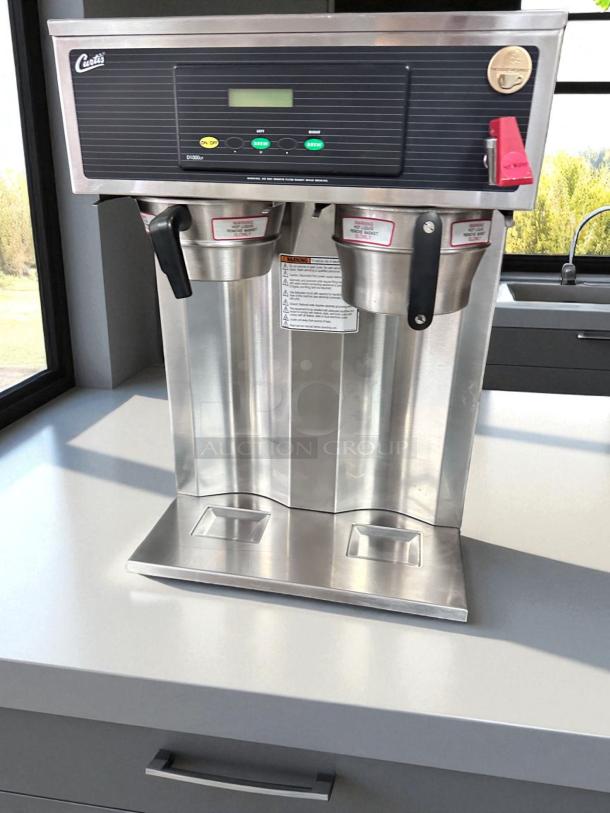 Wilbur Curtis D1000GT12A000 coffee brewer, twin 1.5-gallon capacity, great condition, fully tested, 220V, stainless steel.