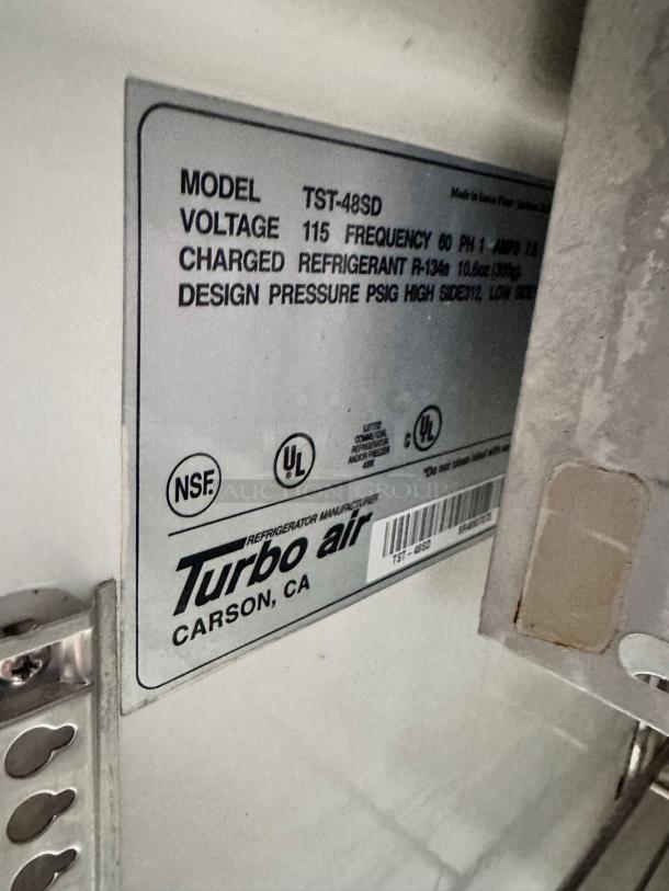 Turbo Air TST-48SD label close-up, showing model, voltage (115V), refrigerant details, and NSF certification.