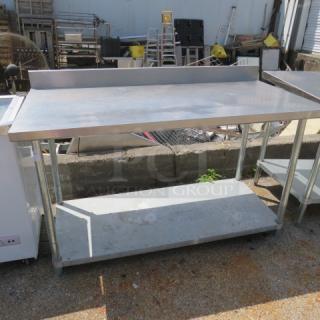 Stainless steel table with under shelf, 60x30x39 inches, used condition. Ideal for kitchen or workshop use.