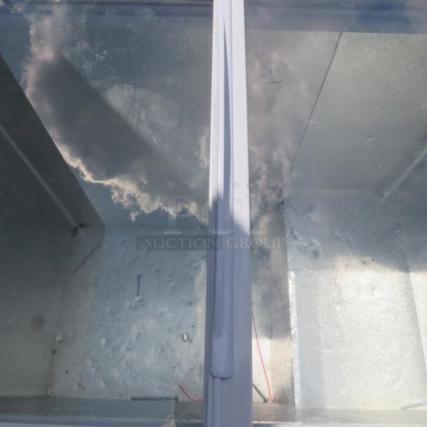 Galaxy flat top display freezer, Model# 177ICFF7HC, 34x21.5x34 inches. Glass top with visible interior. On casters.