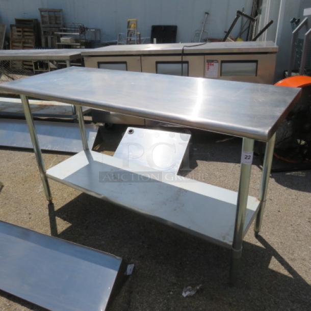 Stainless steel table with under shelf, 60x24x34.5 inches, durable with slight wear. Ideal for kitchen use.