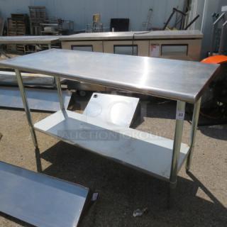 Stainless steel table with under shelf, 60x24x34.5 inches, durable with slight wear. Ideal for kitchen use.