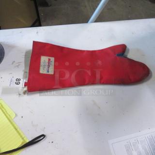 Red Tucker Burn Guard Glove, single, gently used, with safety label visible. Auction item tagged "68".
