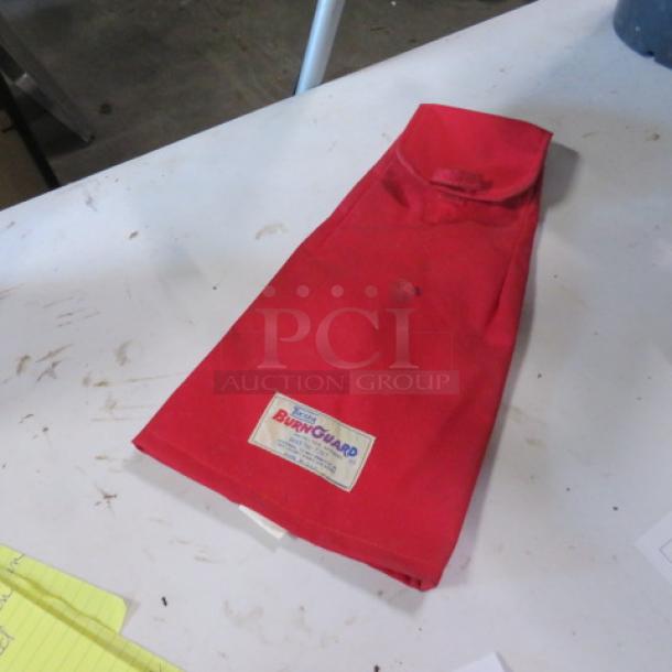 Red Tucker Burn Guard Arm Guard on a table. Features visible label "Burn Guard" indicating brand. Good condition.