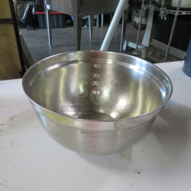 4 quart stainless steel mixing bowl, used condition, visible measurement markings inside, smooth finish.