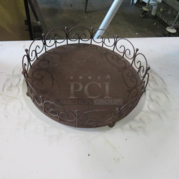 12-inch brown metal bakery display with ornate scrollwork design, in good condition. Perfect for showcasing baked goods.