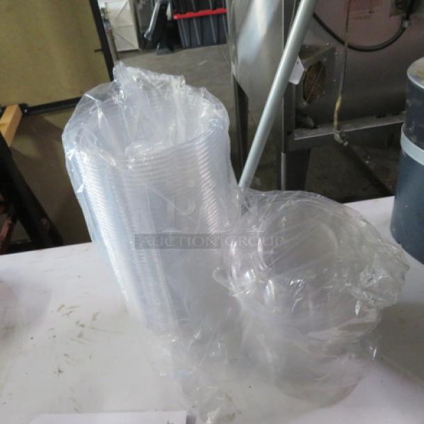 A lot of clear poly salad to-go bowls with lids, wrapped in plastic. Ideal for food service.