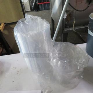 A lot of clear poly salad to-go bowls with lids, wrapped in plastic. Ideal for food service.