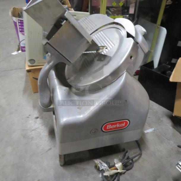Berkel deli slicer, 115 Volt, silver, used but working condition, with visible brand logo on the side.