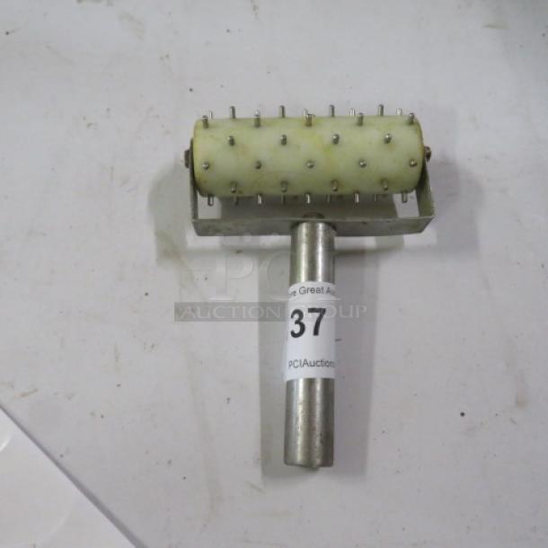 One Roller Docker with metal pins, stainless steel handle, and a label marked "37 PCI Auctions." Good condition.