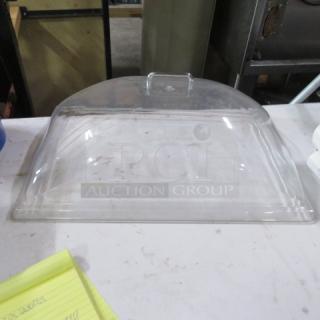 One full-size clear dome lid, gently used, with a handle on top, suitable for covering trays.