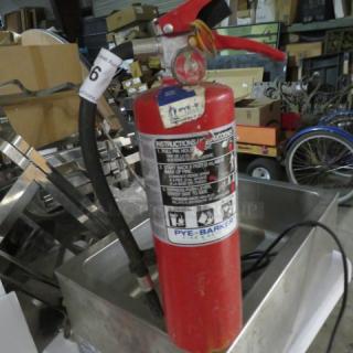 Red ABC fire extinguisher, Pye-Barker brand, attached hose, visible instructions, moderate wear, auction label number 6.