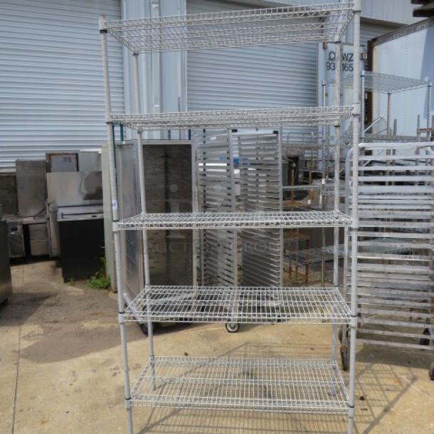 Metro shelf unit with 5 wire shelves, 48x21x87 inches. Sturdy metal construction, ideal for storage. Good condition.
