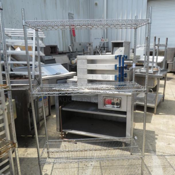 Metro three-shelf wire shelving unit, 48x18x73 inches, stainless steel, used condition. Industrial setting background.