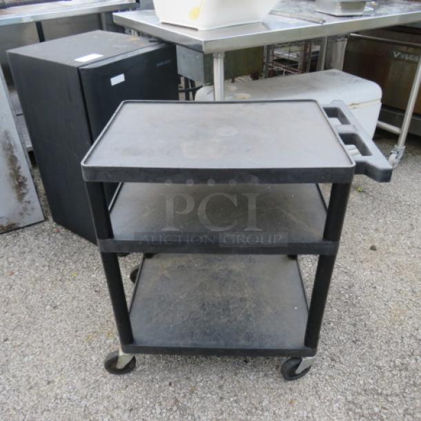 Three-shelf poly cart on casters, 28x18x30 inches, black, used condition, handle and wheels for mobility.