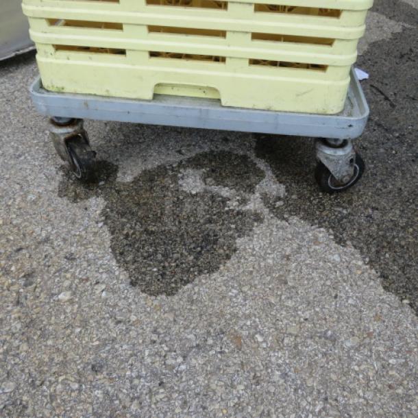 Industrial dishwasher rack dolly with four swivel casters on a concrete surface, used condition.