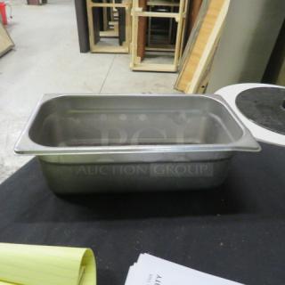 Steel 1/3 size hotel pan, 4-inch deep. Suitable for commercial kitchen use. Appears in good condition. No visible markings.