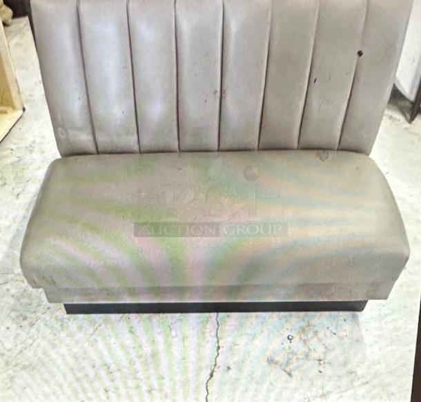 Single-sided gray cushioned booth, 48x27x45, shows wear with stains and scuffs. Ribbed backrest, solid base, commercial use.
