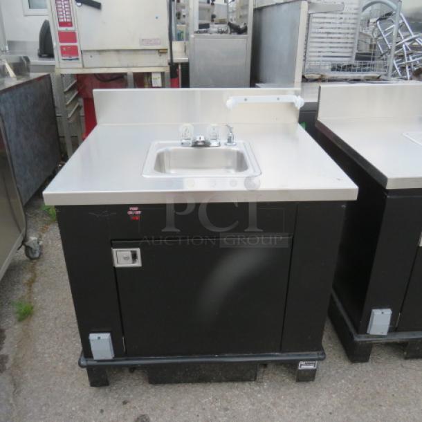 Corsair stainless steel 1-door portable sink with faucet, paper towel holder, 5-gallon fresh water tank, 7-gallon waste tank, on casters.