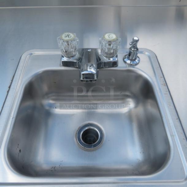 Corsair stainless steel portable sink with faucet, paper towel holder, 5-gallon fresh water tank, and 7-gallon waste tank.
