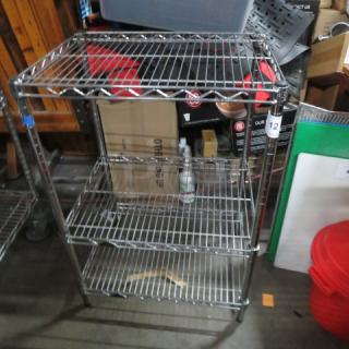Metro shelving unit with three wire shelves, 24x18x36 inches, metal, sturdy condition, ideal for storage organization.