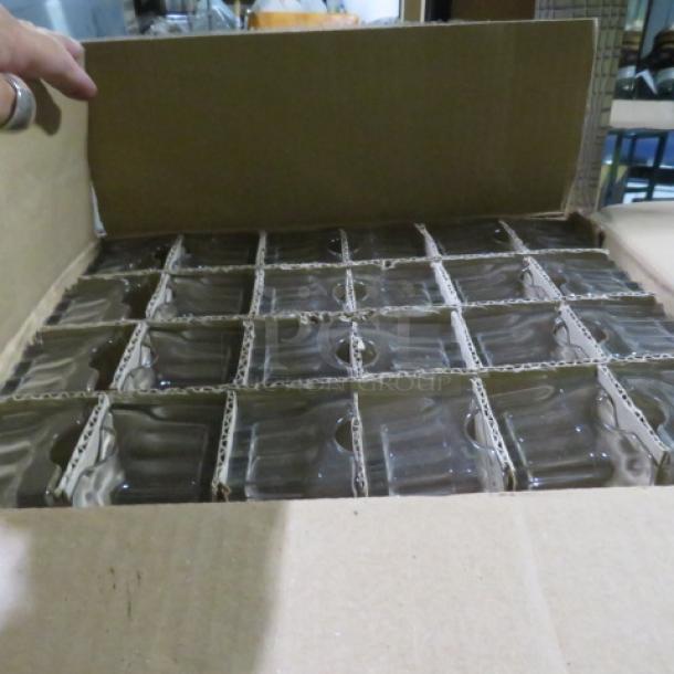 Case of 24 new glass sugar pack holders, neatly packed in a cardboard box. Each holder is separated by cardboard dividers.