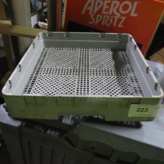 Gray dishwasher rack with grid design, used condition. Label with number "223" on the side.