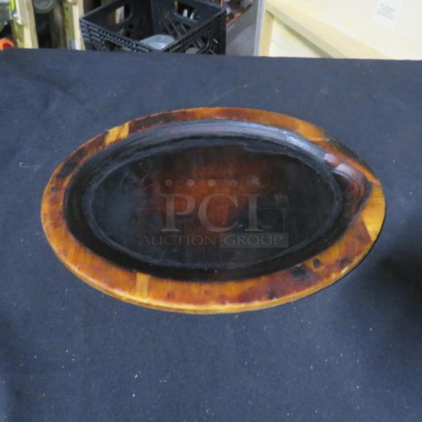 Oval wooden fajita underlay, 12x9 inches. Rich brown finish, slightly worn edges. Item code: 7XBID.