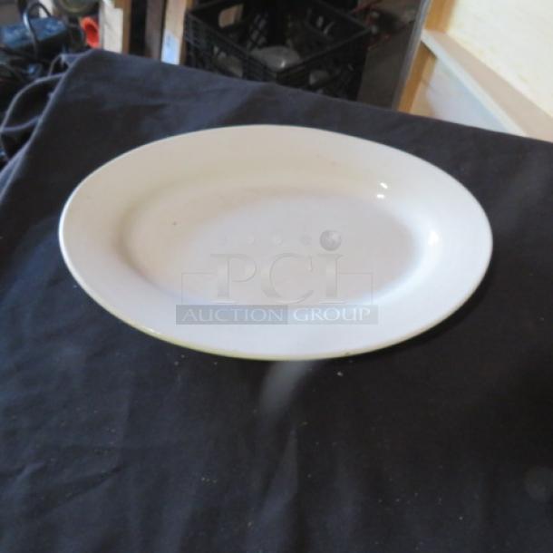 White ceramic platter, 12.5x9 inches, oval shape, minimalist design, good condition. Ideal for dining or display.
