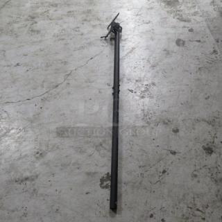 Metal TV mount, black, adjustable length, suitable for wall installation. Shows minor wear, ideal for flat-screen TVs.