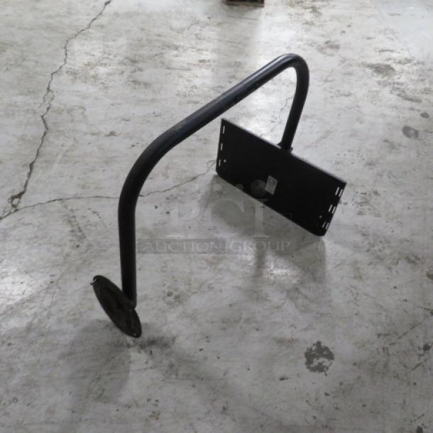 Black metal TV mount with adjustable bracket, used condition. Features a curved arm and flat mounting plate.