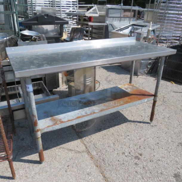 Stainless steel table with under shelf, dimensions 60x24x37.5, some rust on legs and shelf, used condition.