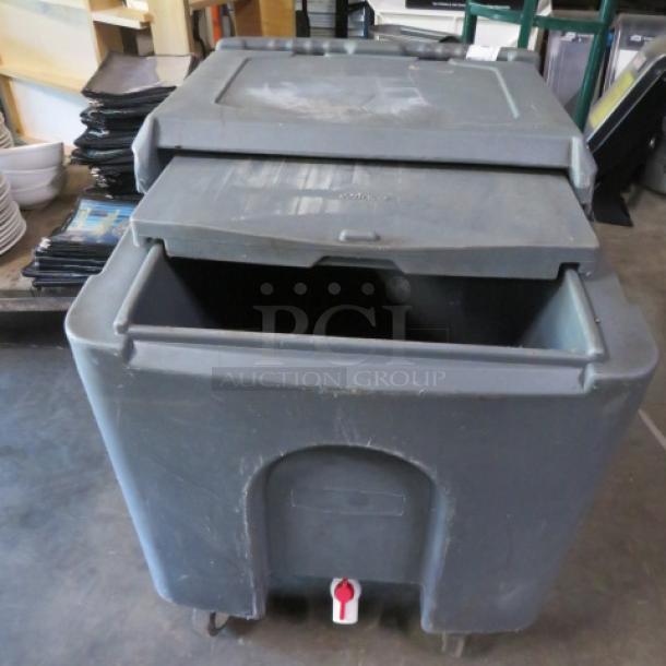 Winco poly ice transport with drain, on casters. Used condition, features a hinged lid and front spigot for drainage.