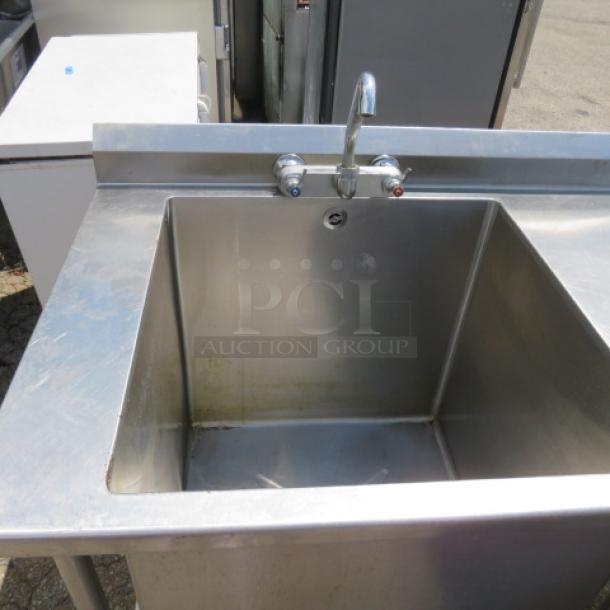 L-shaped stainless steel workspace with handsink and faucet, and large sink with faucet. Dimensions: 81x105x41 inches.