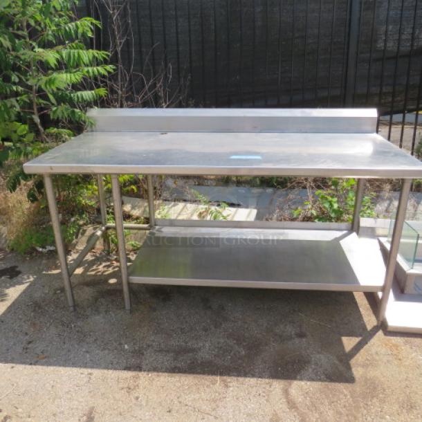 Stainless steel table with backsplash and undershelf, 76x36x43 inches, outdoor display.