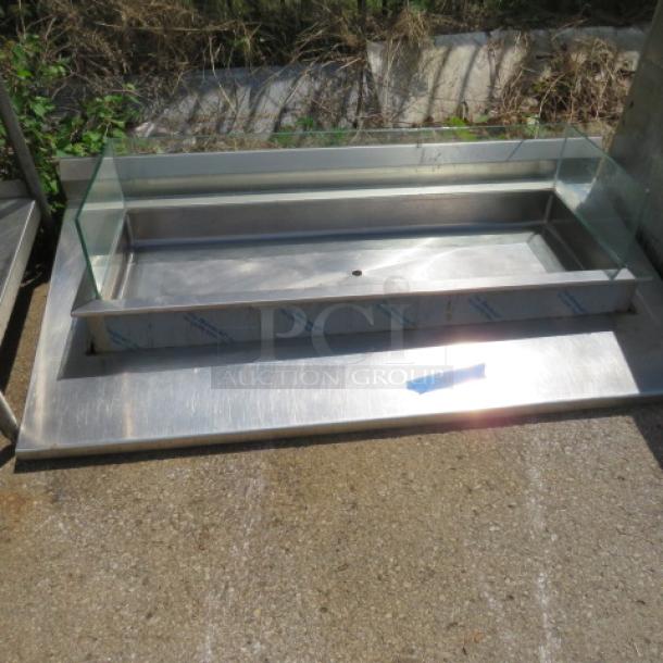 Stainless steel drop-in well with glass surround, 68x36x14 inches, in good condition. Features durable design and smooth finish.