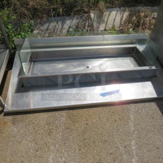 Stainless steel drop-in well with glass surround, 68x36x14 inches, in good condition. Features durable design and smooth finish.