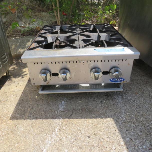 Cookrite 4-burner natural gas range, 24x28x12, with silver finish; visible control knobs; moderate wear; Cookrite logo.