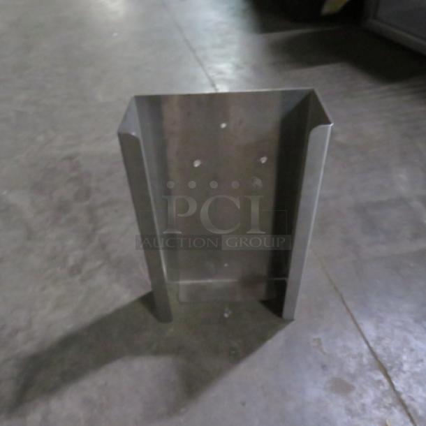 Stainless steel glove box holder, open design, wall-mountable with four screw holes, in good condition.
