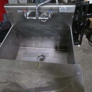 Stainless steel sink with faucet and cover, 26.5x25x41 inches, good condition, visible control tags for hot and cold water.