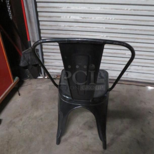 Black metal industrial-look chair with a sleek design, featuring a durable frame and a high backrest. Model: 2XBID.