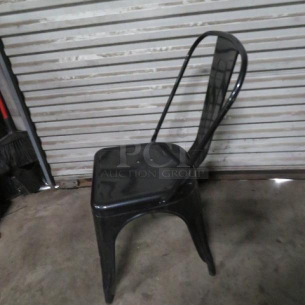 Black metal industrial-look chair, sturdy design, sleek finish, minor wear. No visible tags or labels. 2XBID.