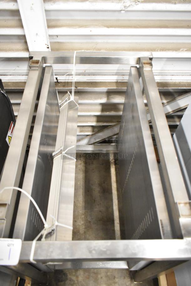 Brand new metal commercial pan rack with minor scratches and dents, visible tags indicating quantity.