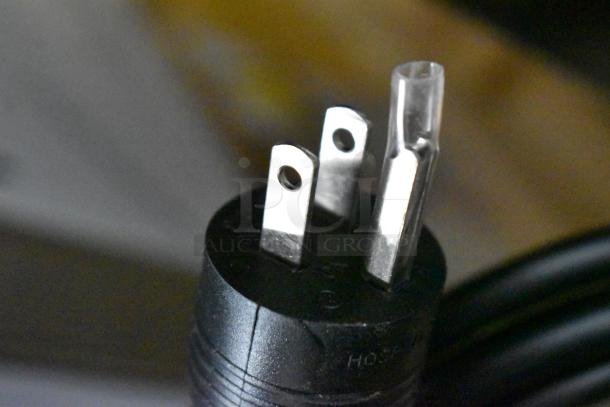 Close-up of a three-prong plug, typically used for electrical appliances, against a blurred background.