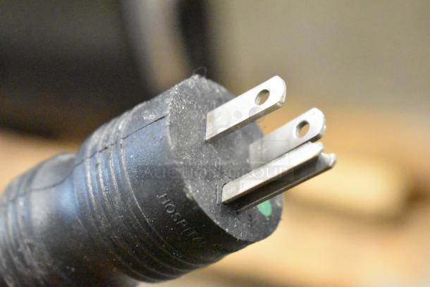 Close-up of a three-prong electrical plug with visible "Hoshizaki" branding, indicating connection compatibility.